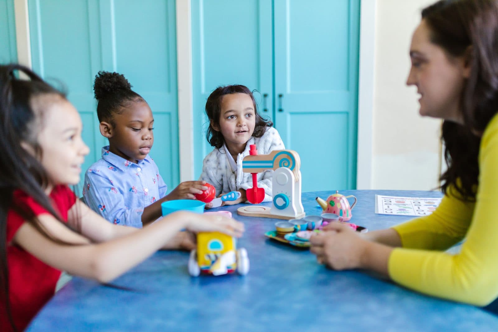 A nursery worker playing with young children
